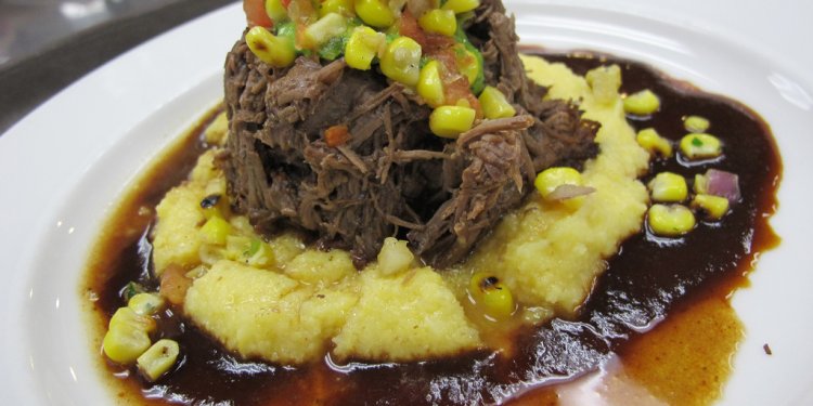 Braised flat iron steak with smoked enchilada sauce, cilantro paste, roasted corn salsa and cheddar cheese...